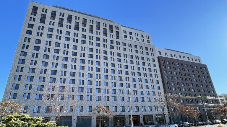 Large building with multiple windows surrounded by blue skies.