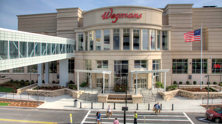 Bird’s eye view of the Wegmans exterior depicting the crosswalk with pedestrian and shopping carts. 