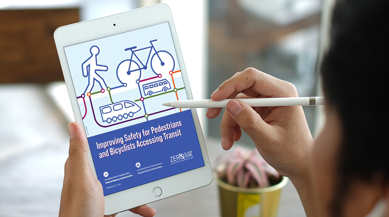 Person holding an iPad with the front cover of the safety guide on display.
