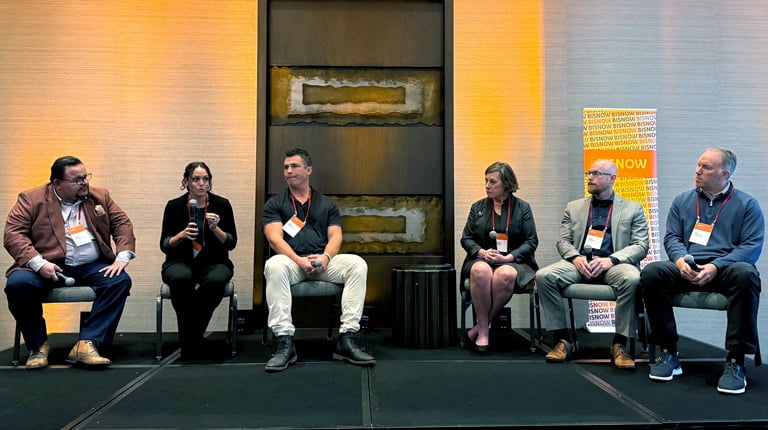 Panel discussion at a Bisnow event featuring five speakers seated in front of an audience.
