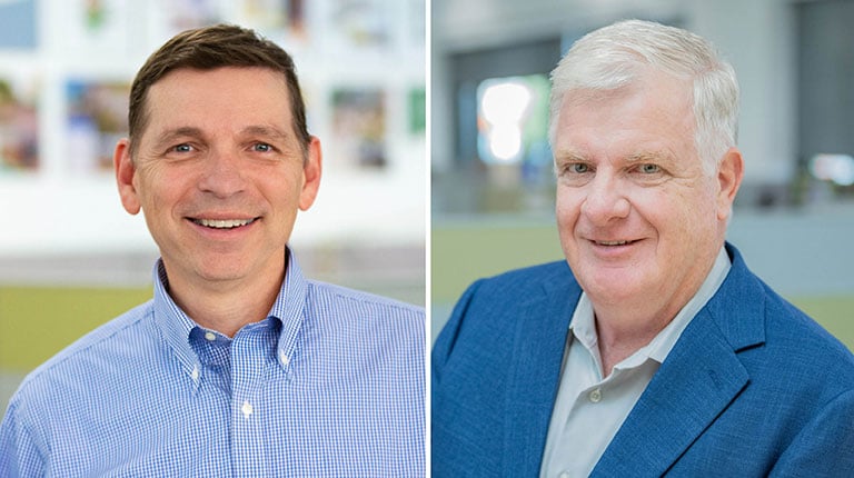 Two men smiling at the camera.