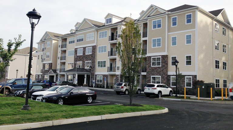 Residential housing development with cars parked in parking lot.