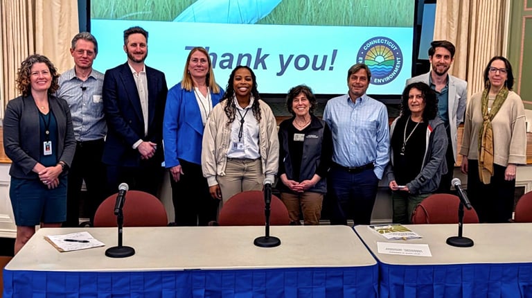 A group of ten people stands on a stage in front of a screen displaying an egret and the words "Thank you!" with a logo on the right side.  
