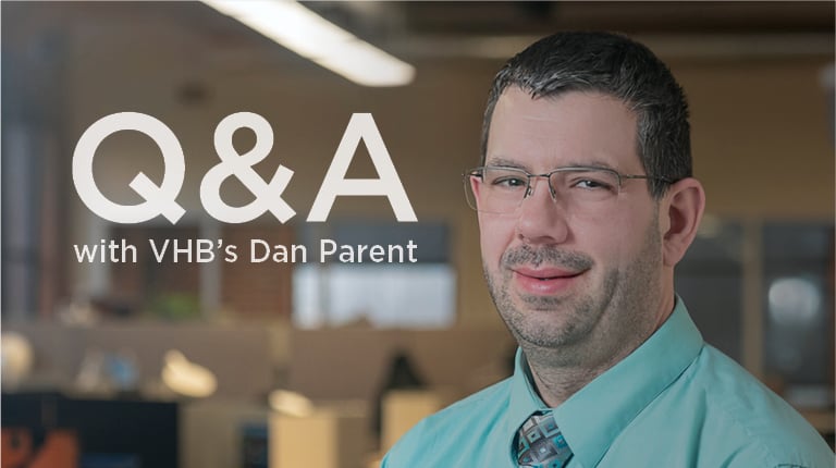Dan Parent smiling in a blue shirt and tie.
