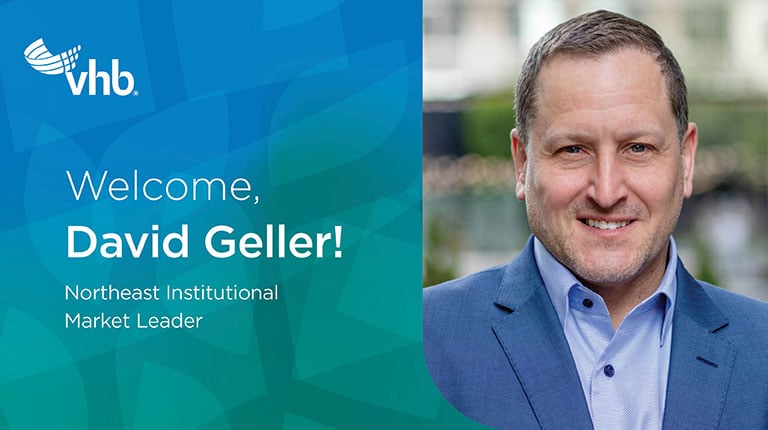 David Geller smiling in blue suit and tie. 