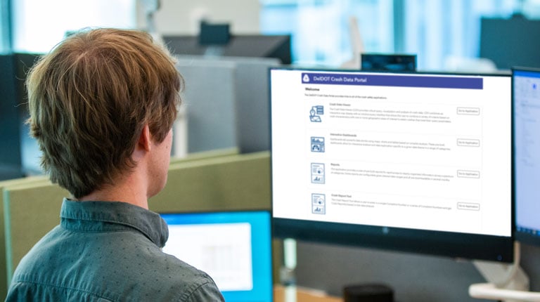 A man looks at a safety dashboard on a monitor at work.