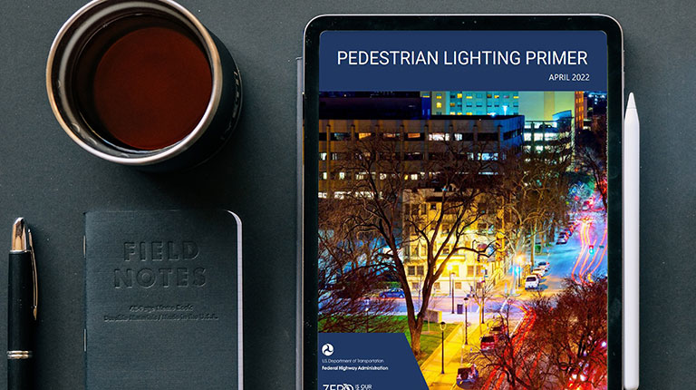A tablet on a table displaying the Pedestrian Lighting Primer report cover. 