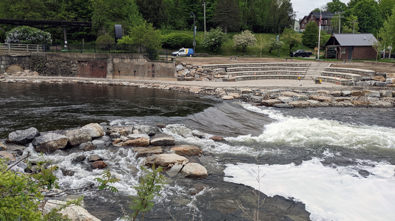 Whitewater rapids with rocks and seating area.