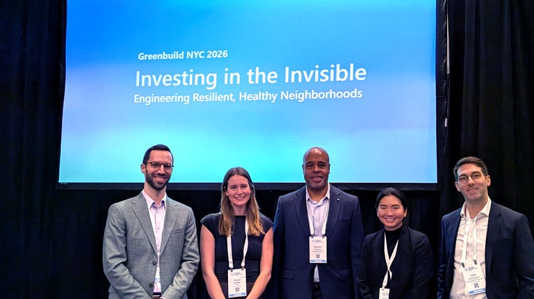Five professionals posing before a presentation screen at Greenbuild NYC 2026. 