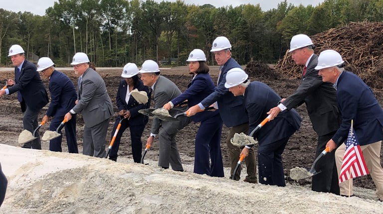 Project stakeholders hold shovels and move dirt to signify the groundbreaking of the new CBOC Hampton Roads.