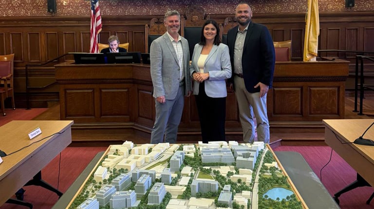 A 3D model of the Alewife campus, along with three professionals.