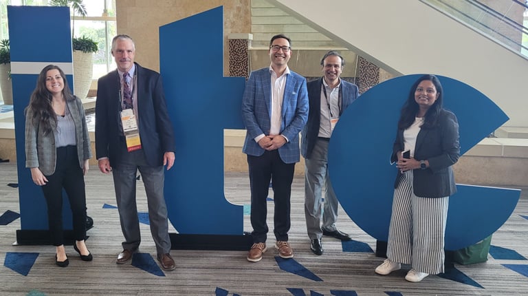 Five people standing in front of large blue letters "ITE" at a conference center.