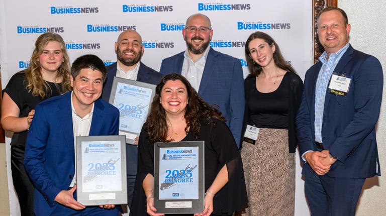 VHB employees smiling while holding awards. 