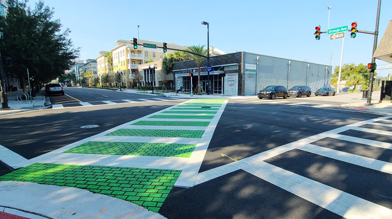 A bright green bicycle and pedestrian path on a city street.