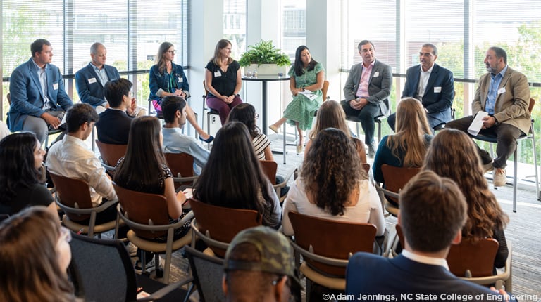 The eight panelists address a group of NC State students.