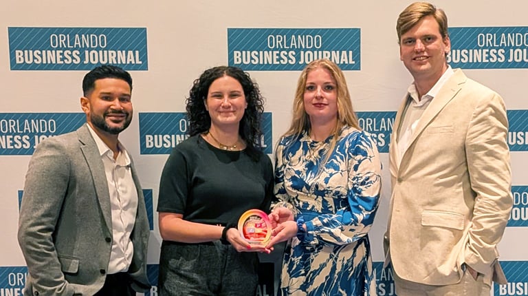 Danny, Julianna, Signe and Stephen standing together by the Orlando Business Journal sign.