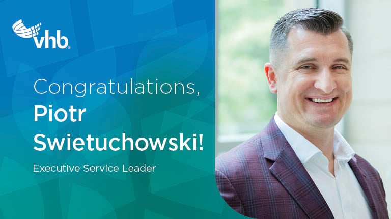 Piotr smiles at the camera.