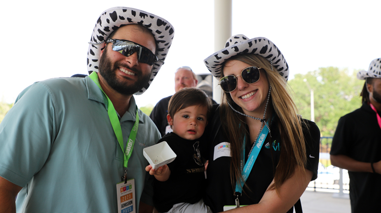 A man, woman, and child wearing funny hats and smiling