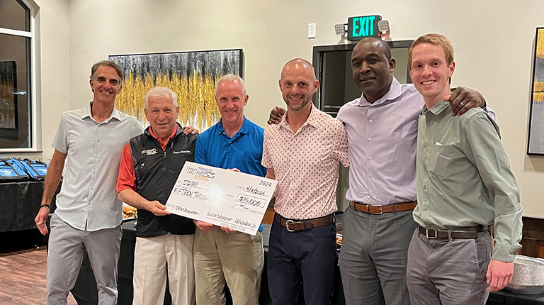 Sean Nicol, far right, presenting a check to local charity with other Tobacco Road Marathon members.