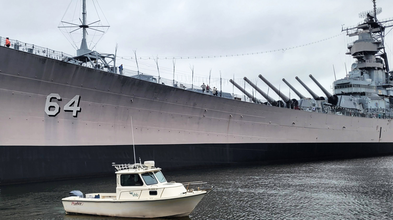 VHB’s vessel floats proudly beside the USS Wisconsin in Norfolk’s harbor.