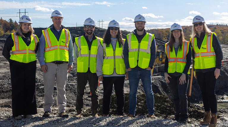 A group of people in protective gear at a groundbreaking.