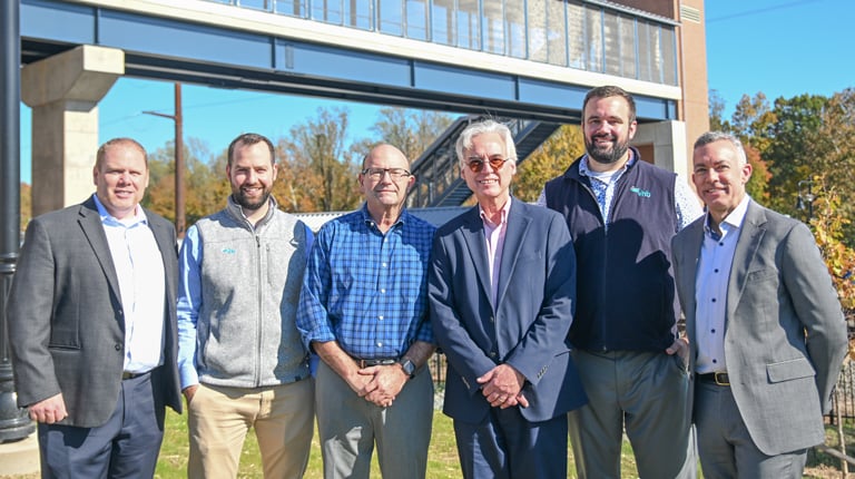 The VHB team stands together in front of the project for a group photo. 