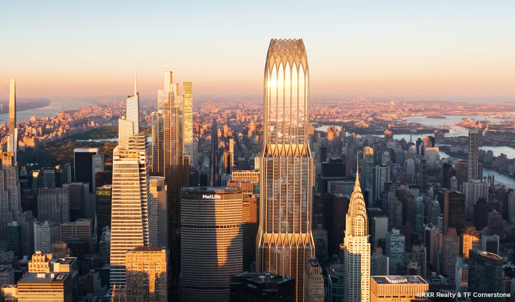 Tall building gleaming in sunlight against a clear sky.