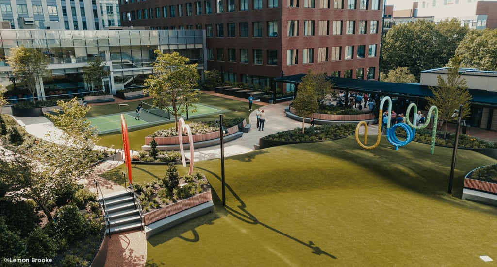 Urban park between buildings with tennis courts.