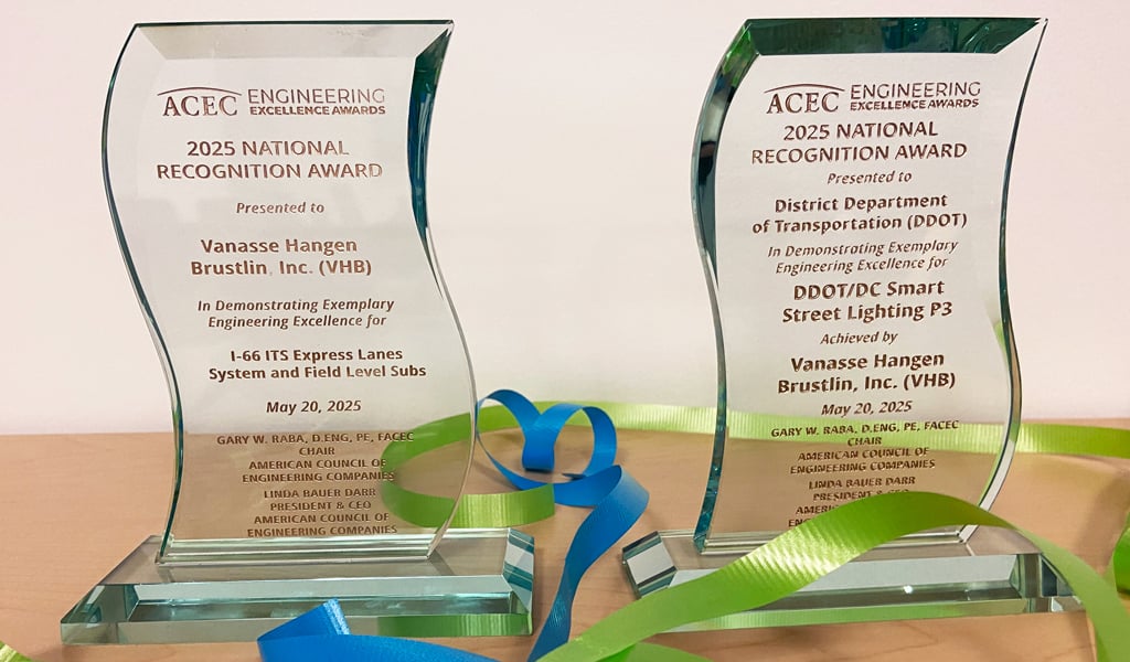 Two VHB projects awards sit on a table with celebratory ribbon.
