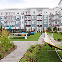 Outdoor leisure space with hammock outside of apartment complex. 