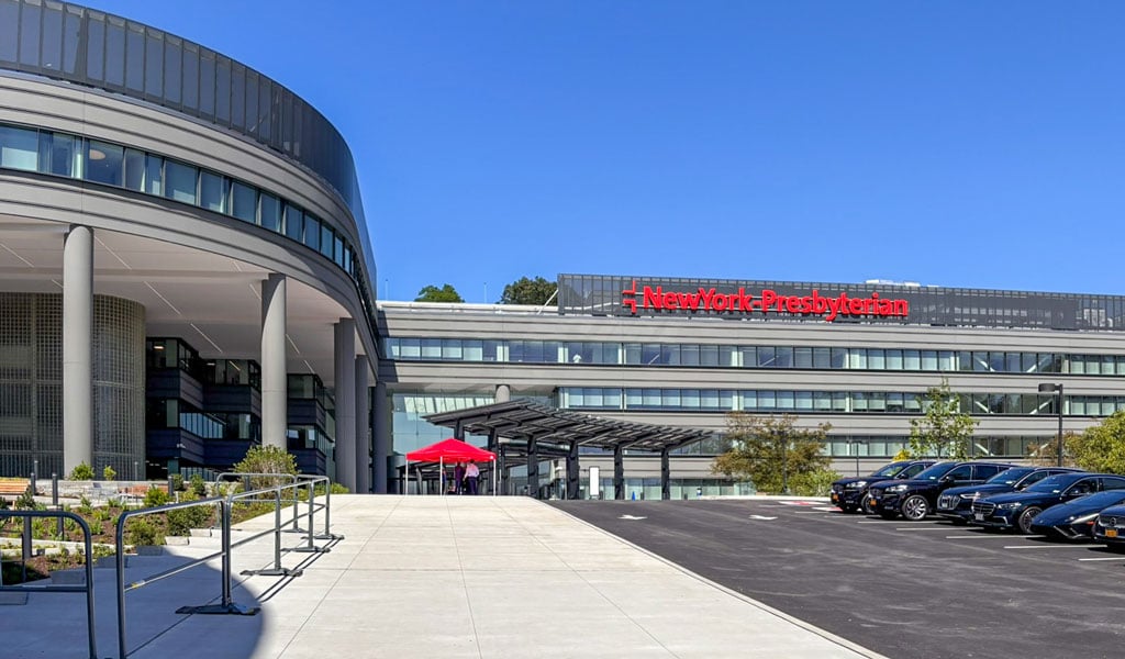 Parking area view of NewYork-Presbyterian The One outpatient facility and surrounding campus circulation.