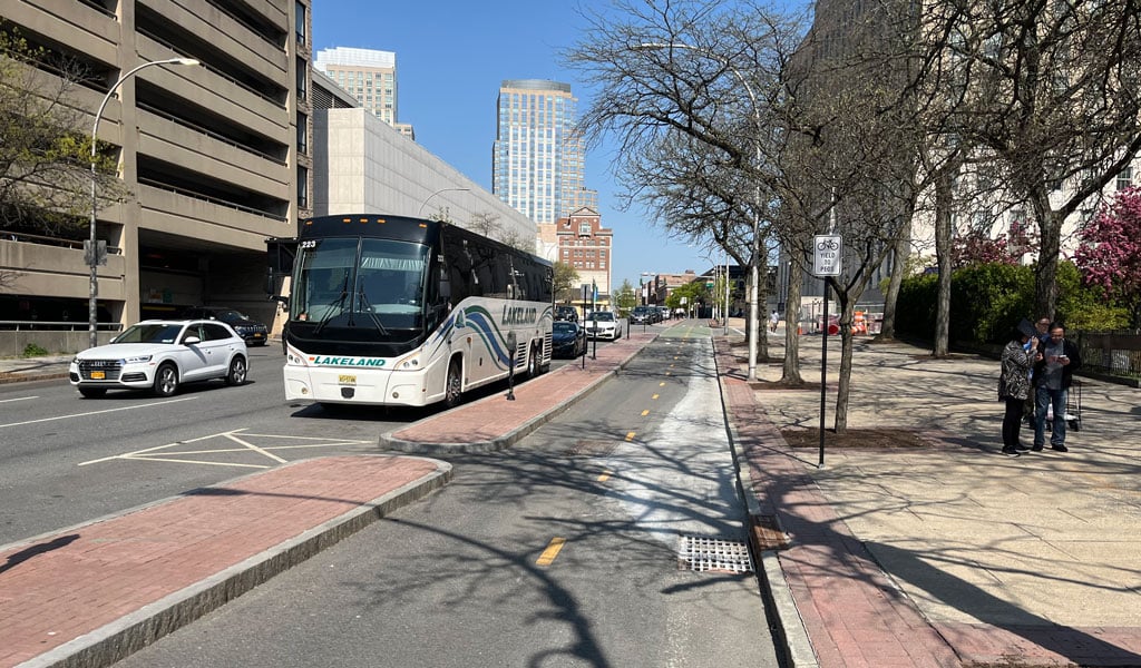 White Plains roadway with bus lane, vehicles, and sidewalk.
