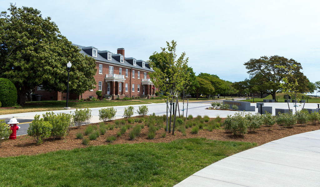View of the African Landing Memorial landscape with planted gardens, walkways, and historic brick barracks at Fort Monroe.