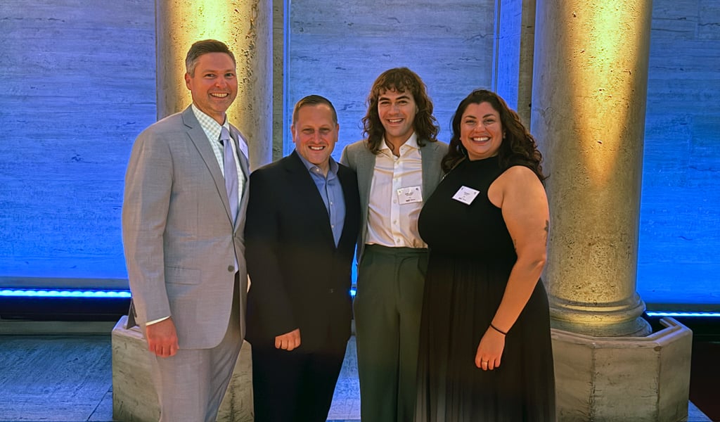 Four VHB team members pose at the 2026 AMFP GNY Awards Gala in front of illuminated columns.