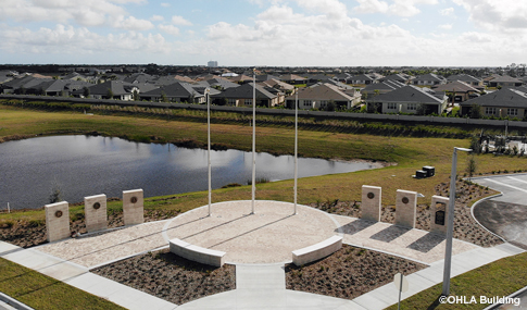 Three stone monuments that have plaques on the front honoring Veterans in front of a Veterans nursing home.