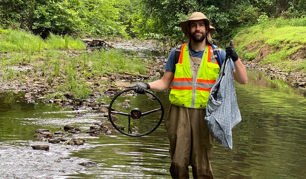 A man cleaning up a river tributary.