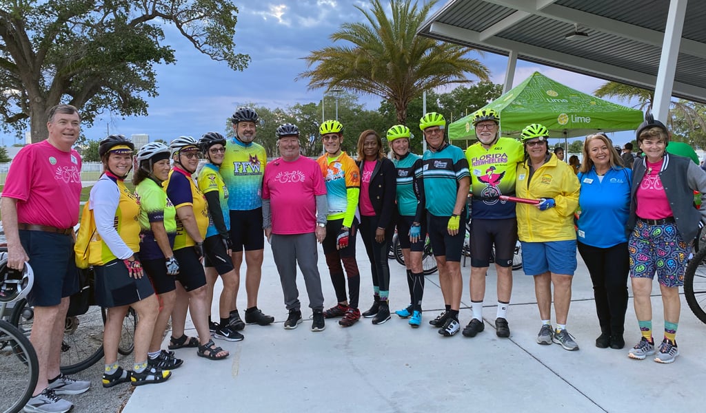 A group of participants wearing bicycle helmets preparing to ride