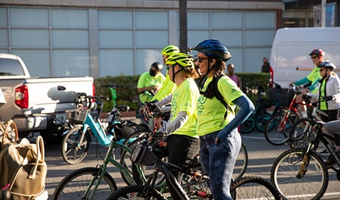 A group of bicyclists in an urban downtown setting