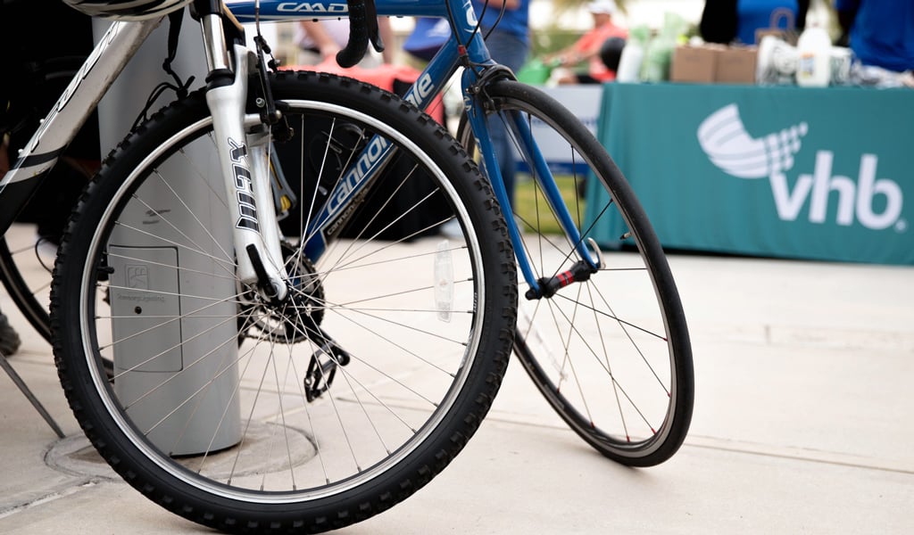 Two bicycles parked near a VHB display at an outdoor event.