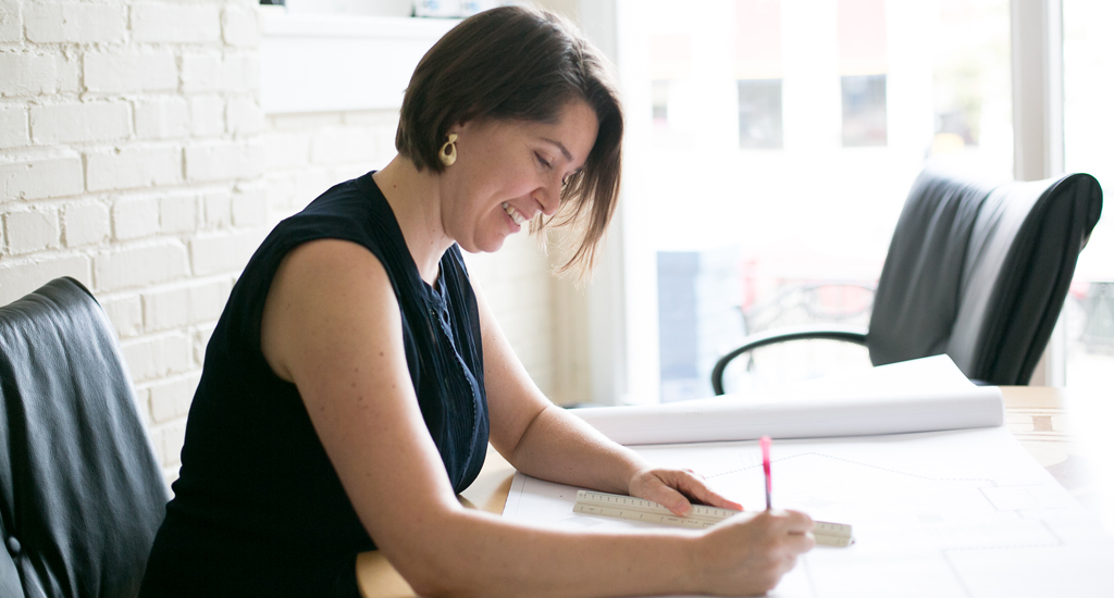 Charlene writes on plans at her desk