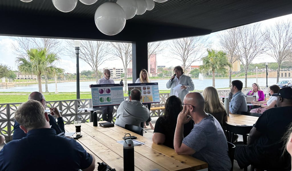 During a stakeholder social event, attendees sit and listen to the draft plan and share feedback. 