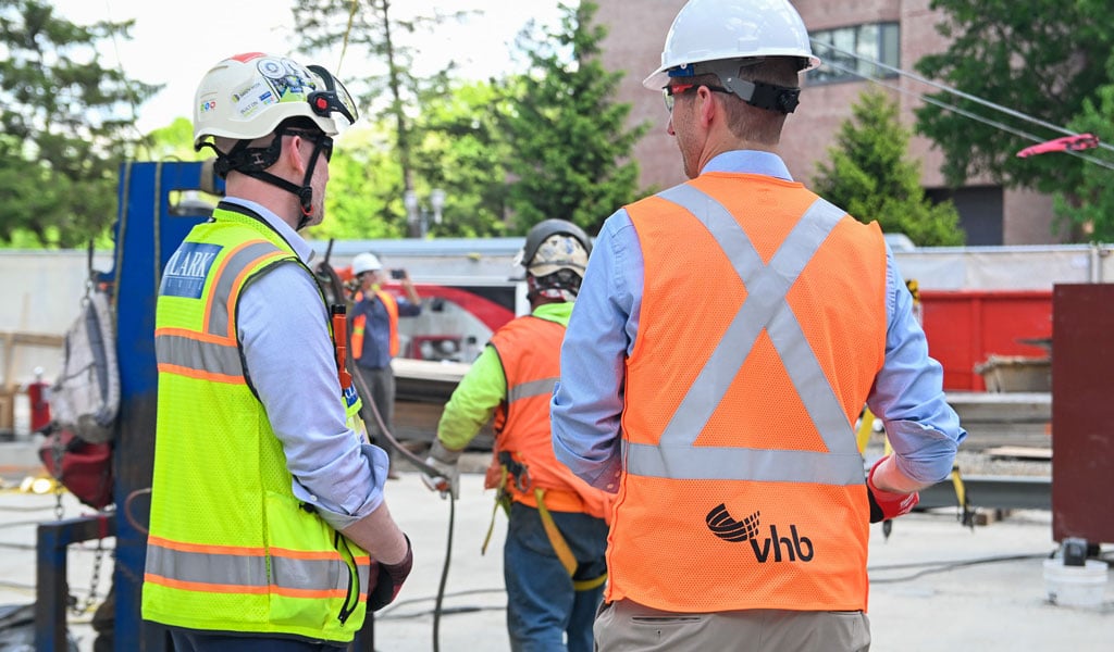 A person from Clark Construction chats with VHB’s Travis Cook on the construction site.