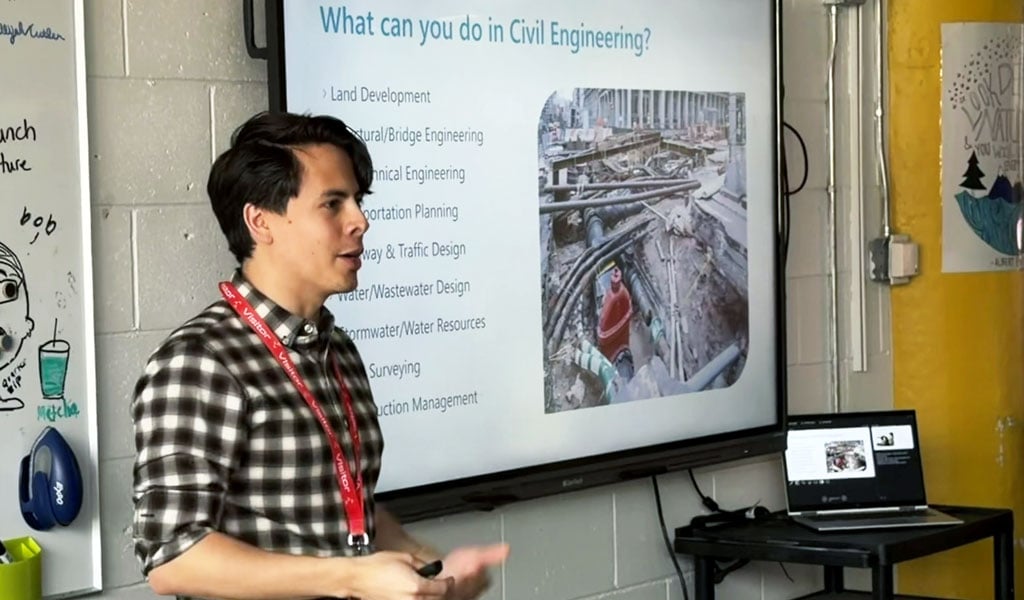 A young man in a checked shirt giving a presentation