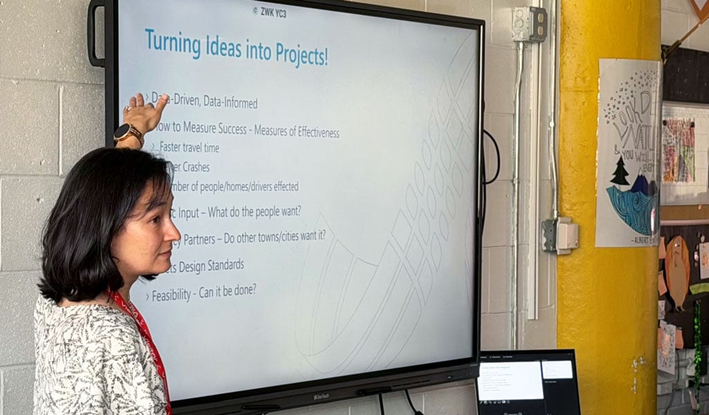 A dark-haired woman giving a presentation