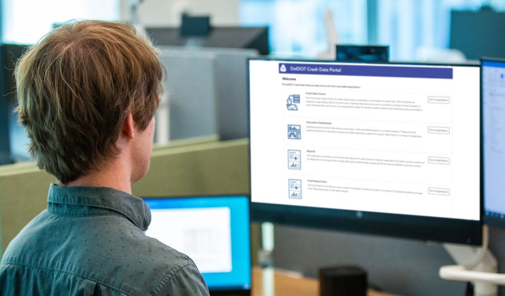 A man looks at a safety dashboard on a monitor at work.