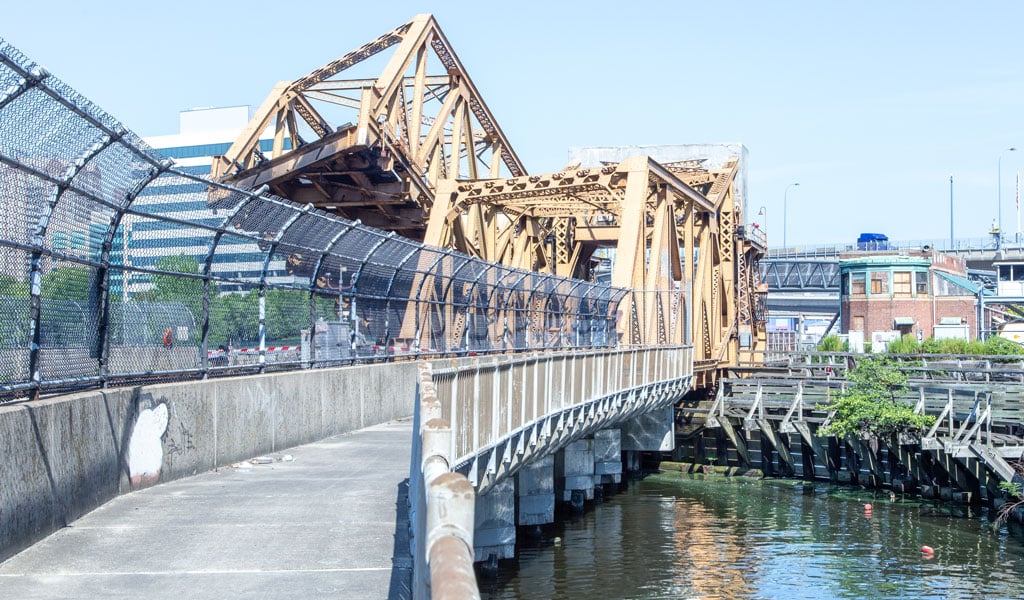 A pedestrian bridge parallel to a partially-raised draw bridge