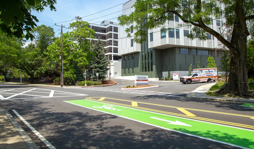 A multistory gray hospital flanked by trees.