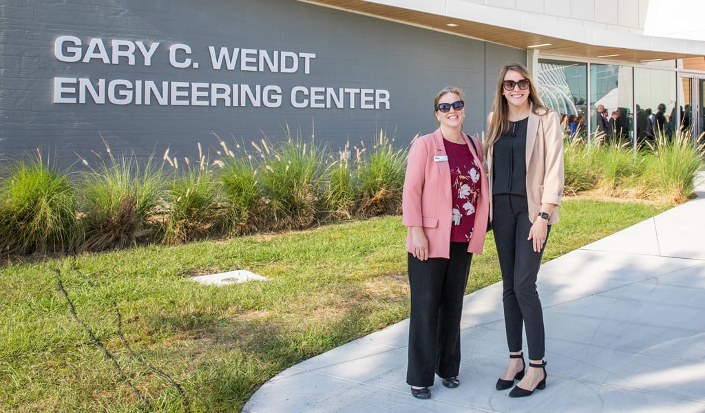 Ivy Clinton and Cameron Langerman stand in front of the new building.