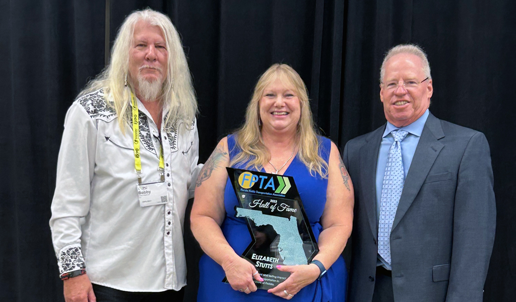 Liz Stutts hold her FPTA award with two colleagues.