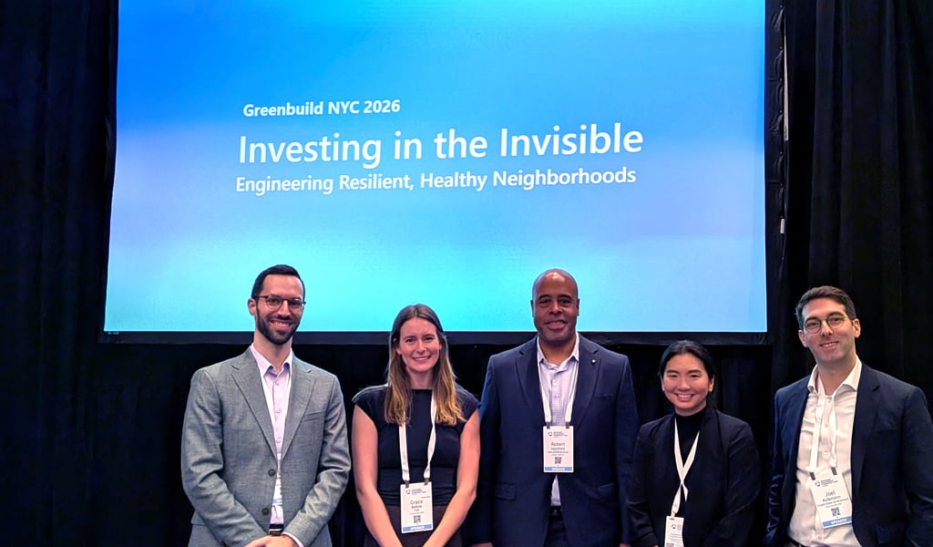 Five professionals posing before a presentation screen at Greenbuild NYC 2026. 